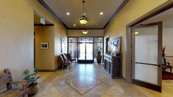A hotel lobby with a reception desk, seating area, and a large window.