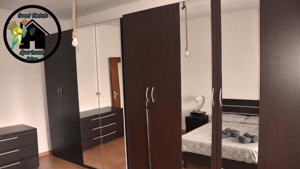 A bedroom with a large wardrobe, a bed, and a bedside table. - Apartment (Torino)