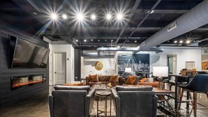 Ein modernes Wohnzimmer mit Flachbildfernseher, Ledersofas, Couchtisch und Kamin.
