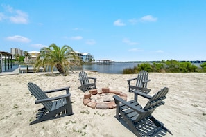 Relax by the fire pit surrounded by Adirondack chairs, overlooking the ocean and dock.