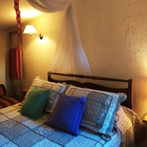 A bed with a quilt, pillows, and a canopy. - Casita Antigua Cerquita del Lago (Villa del Dique)