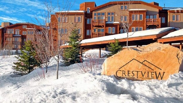Un edificio cubierto de nieve con un letrero que dice "CRESTVIEW".
