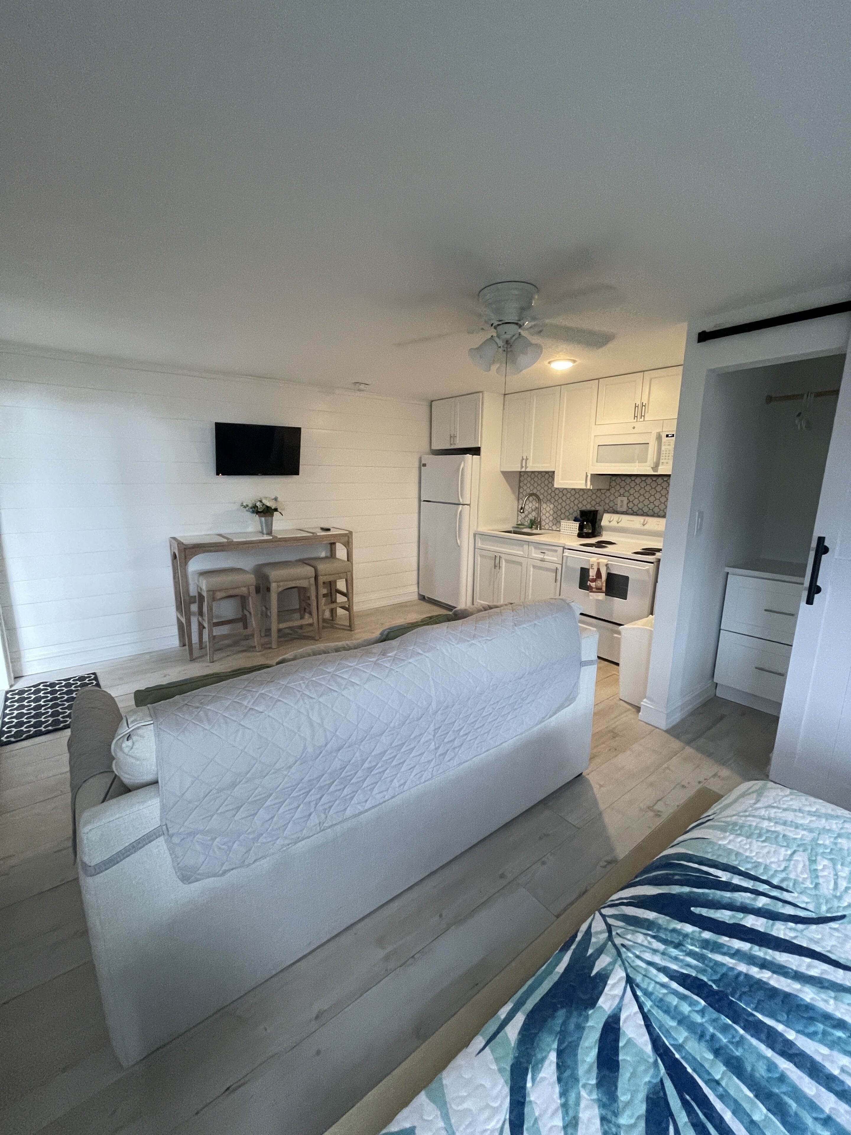 A compact living space with a kitchenette, a dining area, and a bed.