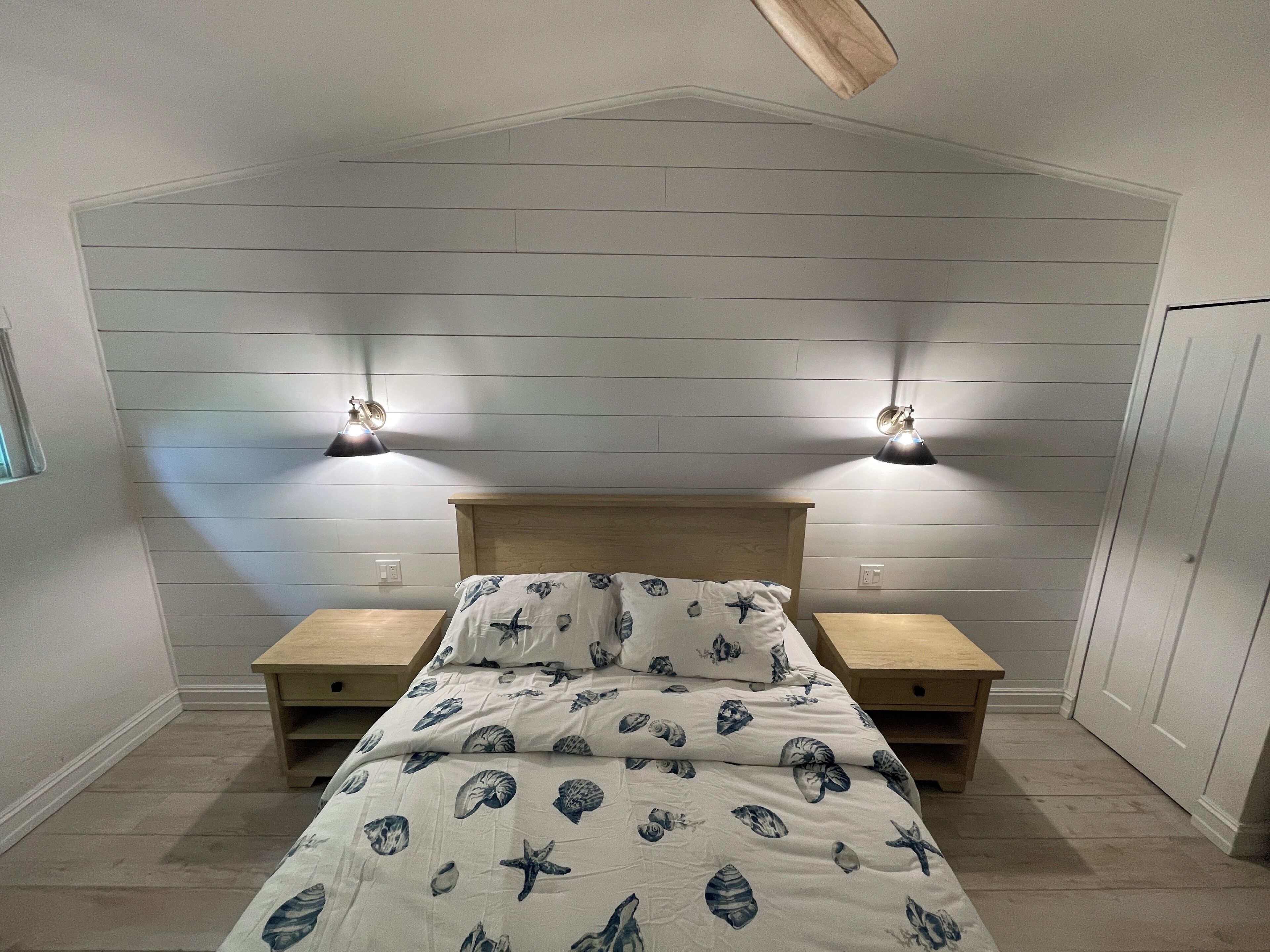 Ein Schlafzimmer mit einem Bett, zwei Nachttischen und zwei Wandleuchten.