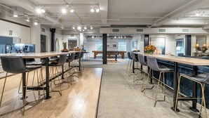 A modern kitchen with a long counter, bar stools, and a central island.