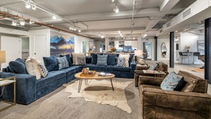 A modern living room with a sectional sofa, a round coffee table, and a brown armchair.