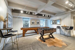 Relax in this stylish room with a foosball table, comfortable seating, and a cozy reading nook.