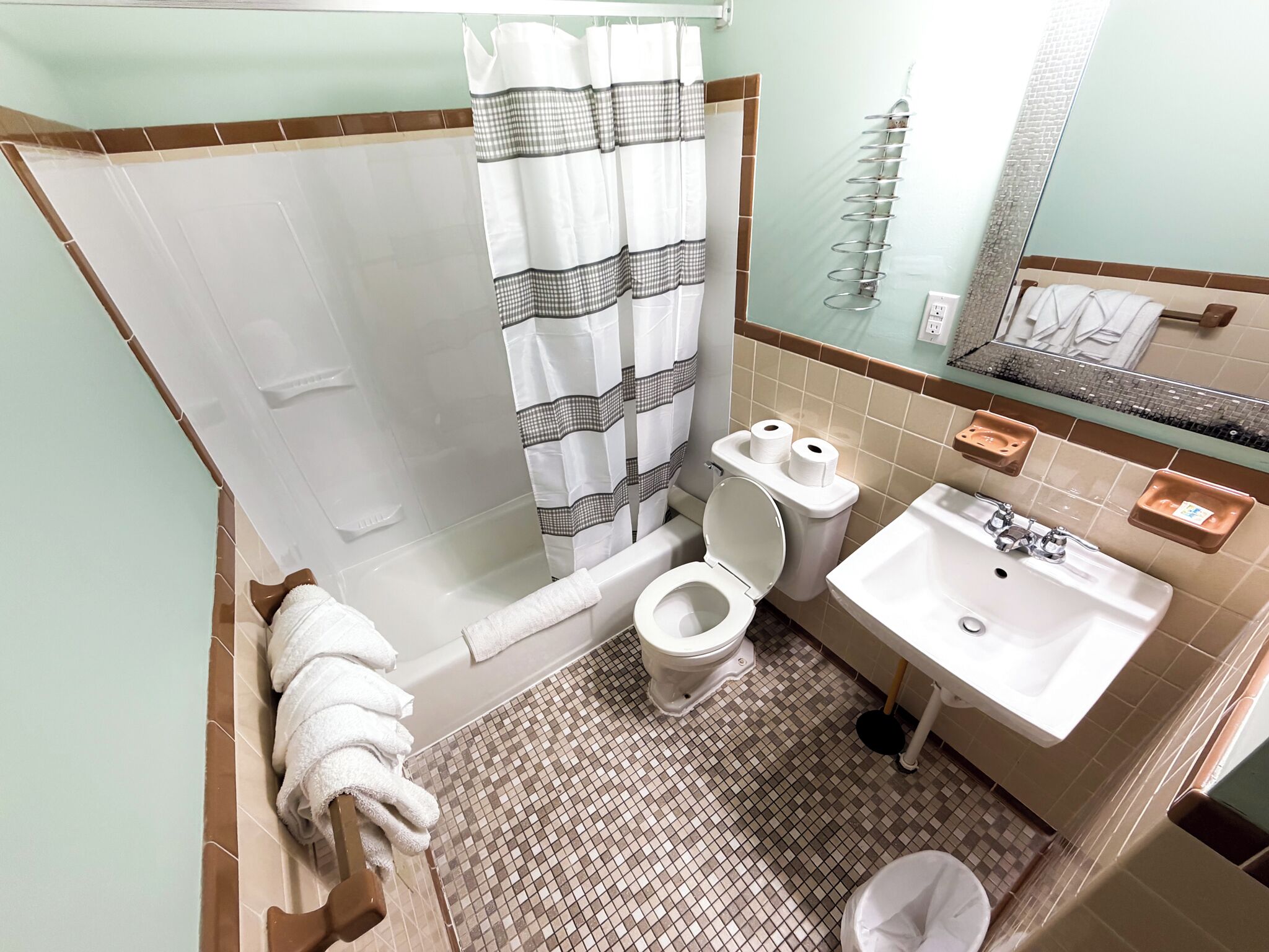 Ein Badezimmer mit Dusche, Toilette, Waschbecken und Handtuchhalter.