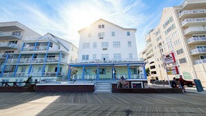 A hotel with a white facade, multiple balconies, and a boardwalk in front. - Majestic Hotel & Apartments (Ocean City)