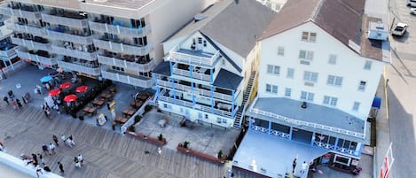 A multi-story hotel with outdoor seating and a boardwalk area.