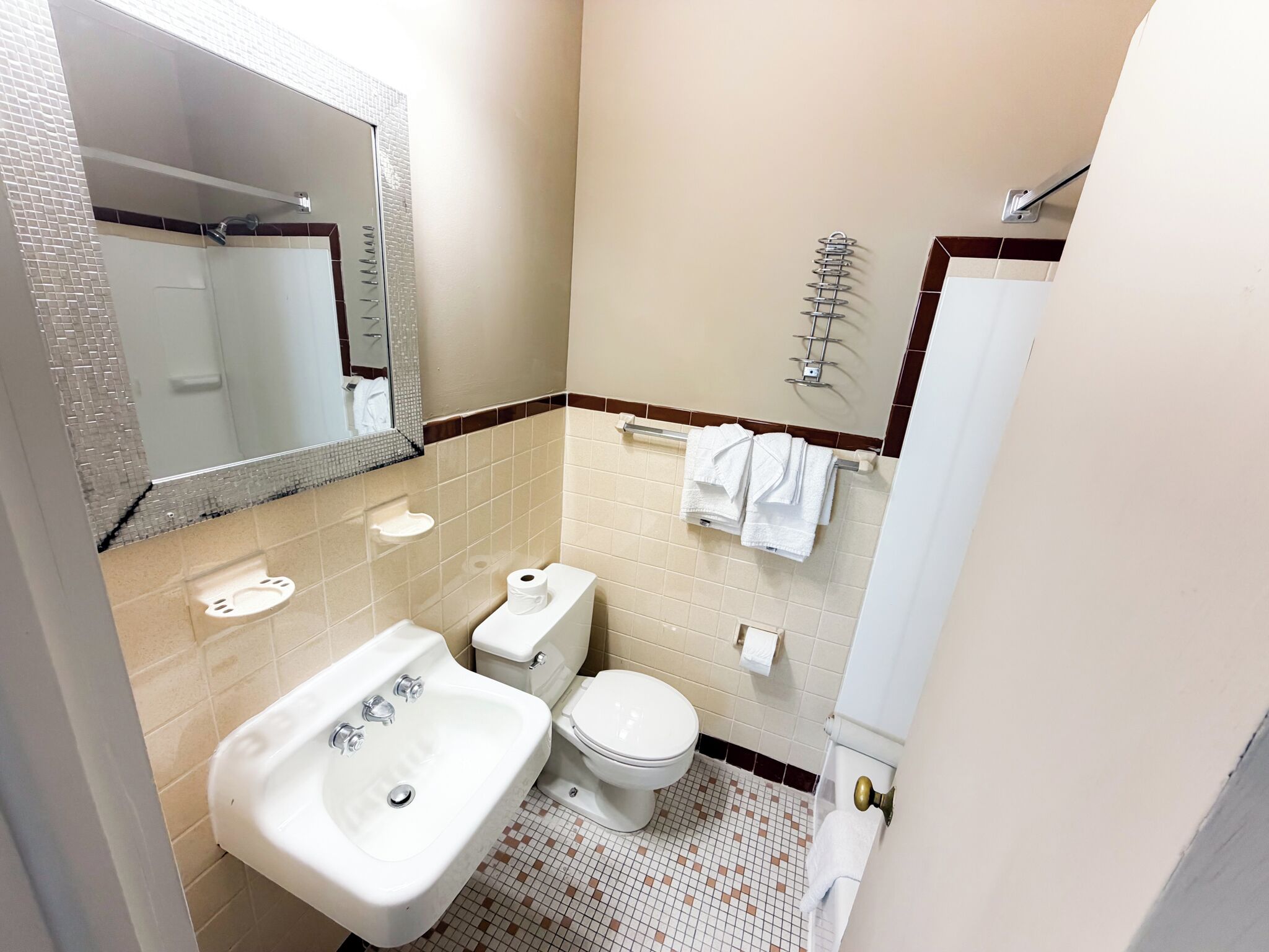 Un baño con lavamanos, inodoro y espejo.