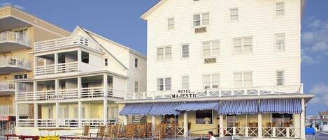 A hotel with a white facade, a balcony, and a sign reading "HOTEL MAJESTIC".
