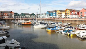 A marina with various boats docked, surrounded by colorful buildings. - Crablake Farmhouse (Exeter)