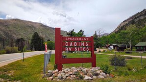 A sign for Sporsman's cabins and RV sites with a road in the background.