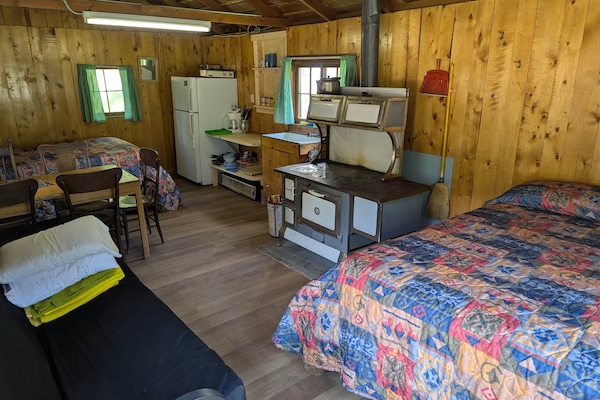 Cabin 3 is a cozy rustic cabin that features a wood-burning stove.