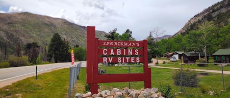 A sign for Sporsman's cabins and RV sites with a road in the background.