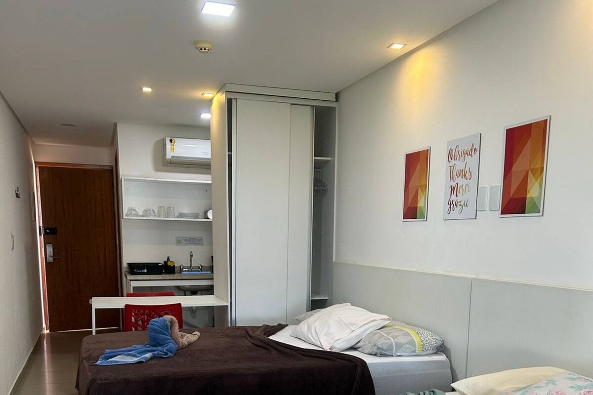 Ein Hotelzimmer mit zwei Betten, einer Küchenzeile und einem Kleiderschrank.