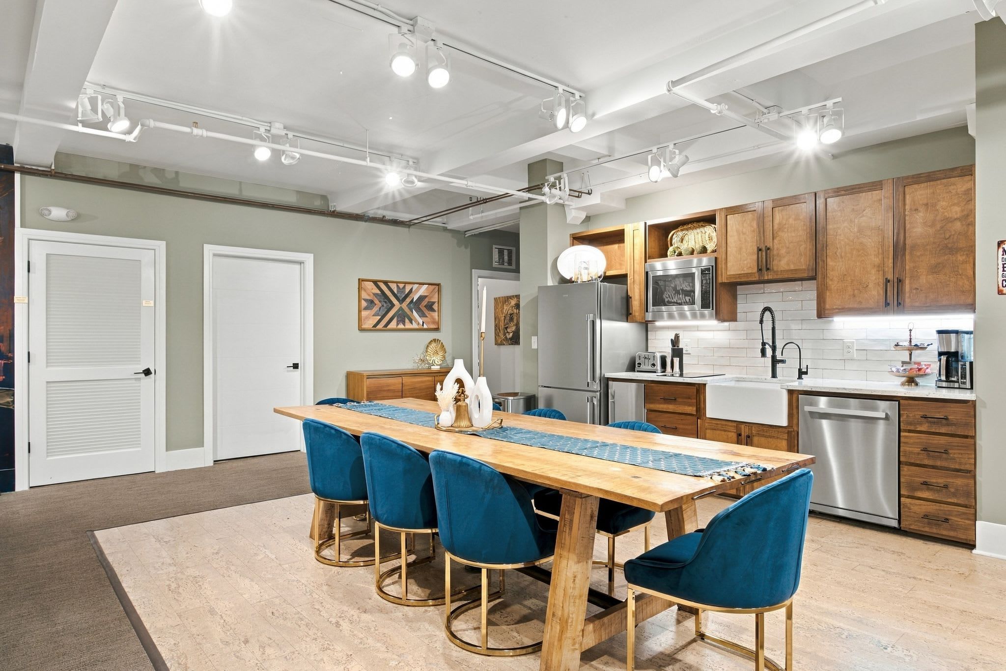 Una cocina moderna con una isla central, electrodomésticos de acero inoxidable y armarios de madera.