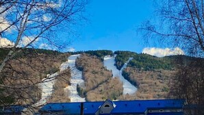 Ein Gebäude mit blauem Dach, umgeben von Schnee, mit einem Berg im Hintergrund.