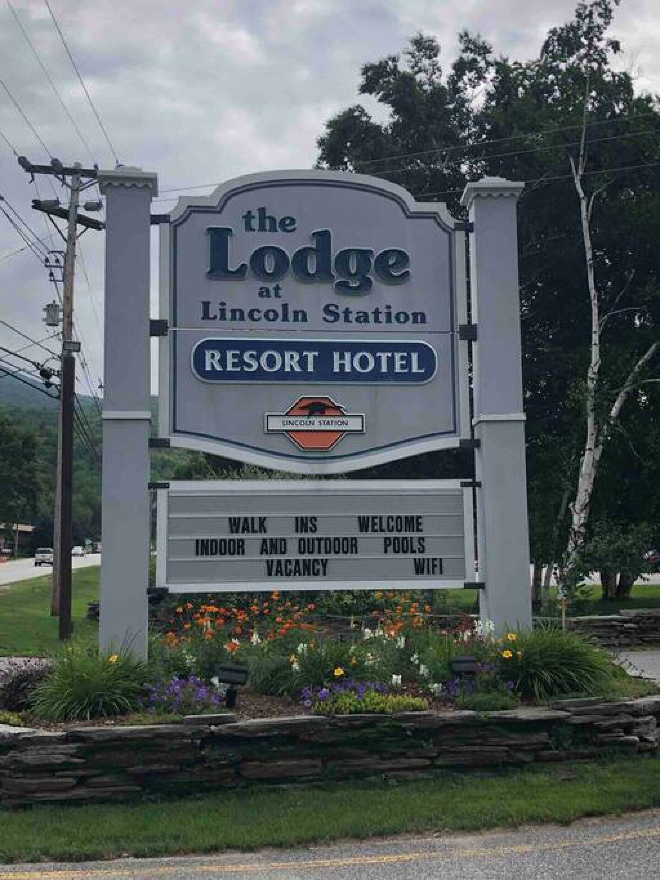 Skilt for The Lodge at Lincoln Station Resort Hotel, der fremhæver faciliteter som direkte adgang, indendørs- og udendørs swimmingpools samt WiFi.