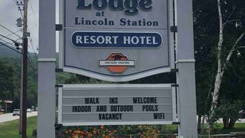 Skilt for The Lodge at Lincoln Station Resort Hotel, der fremhæver faciliteter som direkte adgang, indendørs- og udendørs swimmingpools samt WiFi.