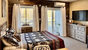 Un dormitorio con cama, cómoda, televisor y ventilador de techo.