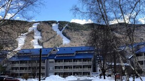 A hotel with a blue roof, a sign reading "The Lodge," and a snow-covered landscape with a mountain in the background. - Top 5 Pct Hotel Room with King Bed and Stunning Loon Mountain Views (Lincoln)