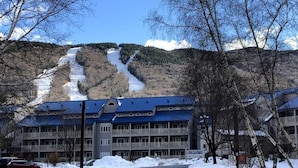A hotel with a blue roof, a sign reading "The Lodge," and a snow-covered landscape with a mountain in the background. - Top 5 Pct Hotel Room with King Bed and Stunning Loon Mountain Views (Lincoln)