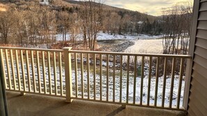 Ein Balkon mit Blick auf eine verschneite Landschaft und einen Fluss.