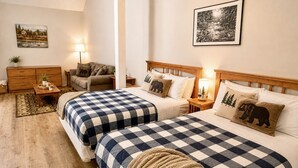 Un dormitorio con dos camas, una mesita de noche, una lámpara, un aparador y una alfombra.