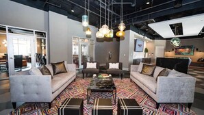 A modern lounge area with sofas, a coffee table, and hanging pendant lights.