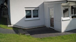 A white building with a covered porch, a small window, and a door. - Quietly located vacation apartment in Reichshof Eckenhagen (Reichshof)