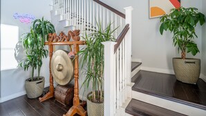 Een trap met houten leuning, plantenbakken en een decoratief wandobject.