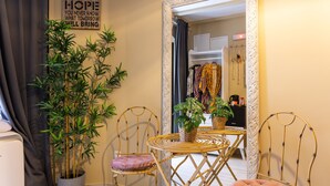 Une pièce avec un miroir, deux chaises, une petite table et une plante en pot.