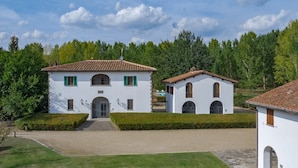 A two-story building with a tiled roof, a central entrance, and a smaller attached structure with arched windows. - Villa Eama - Tuscan Villa with Private Pool (Pian di Scò)