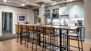 A modern kitchen with a central island, bar stools, and stainless steel appliances. - Honky Tonk Suite/6 BR/3600sqft, Walkto Broadway (Nashville)
