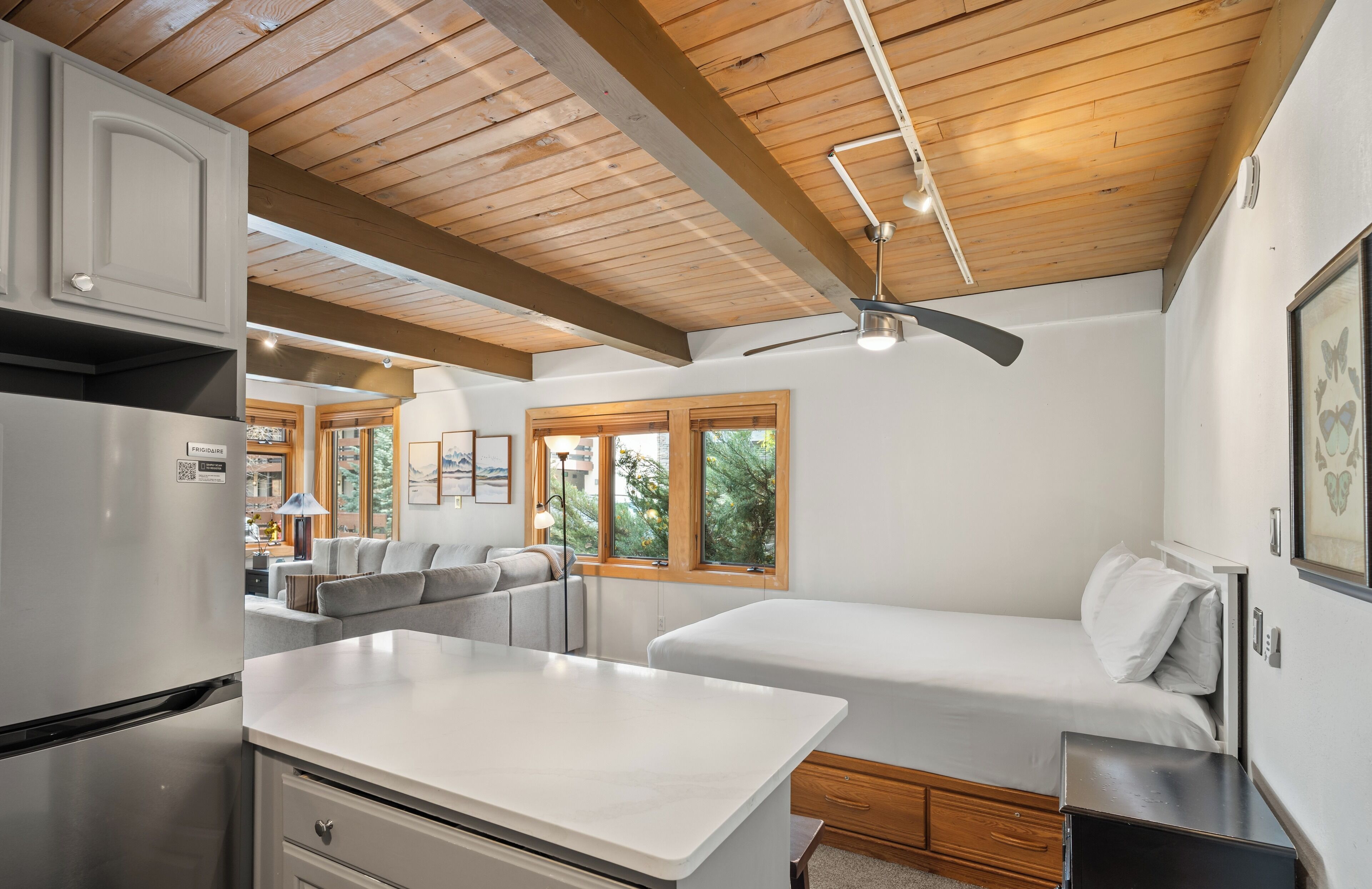 Una cocina moderna con refrigerador empotrado, una mesa de comedor y un ventilador de techo.
