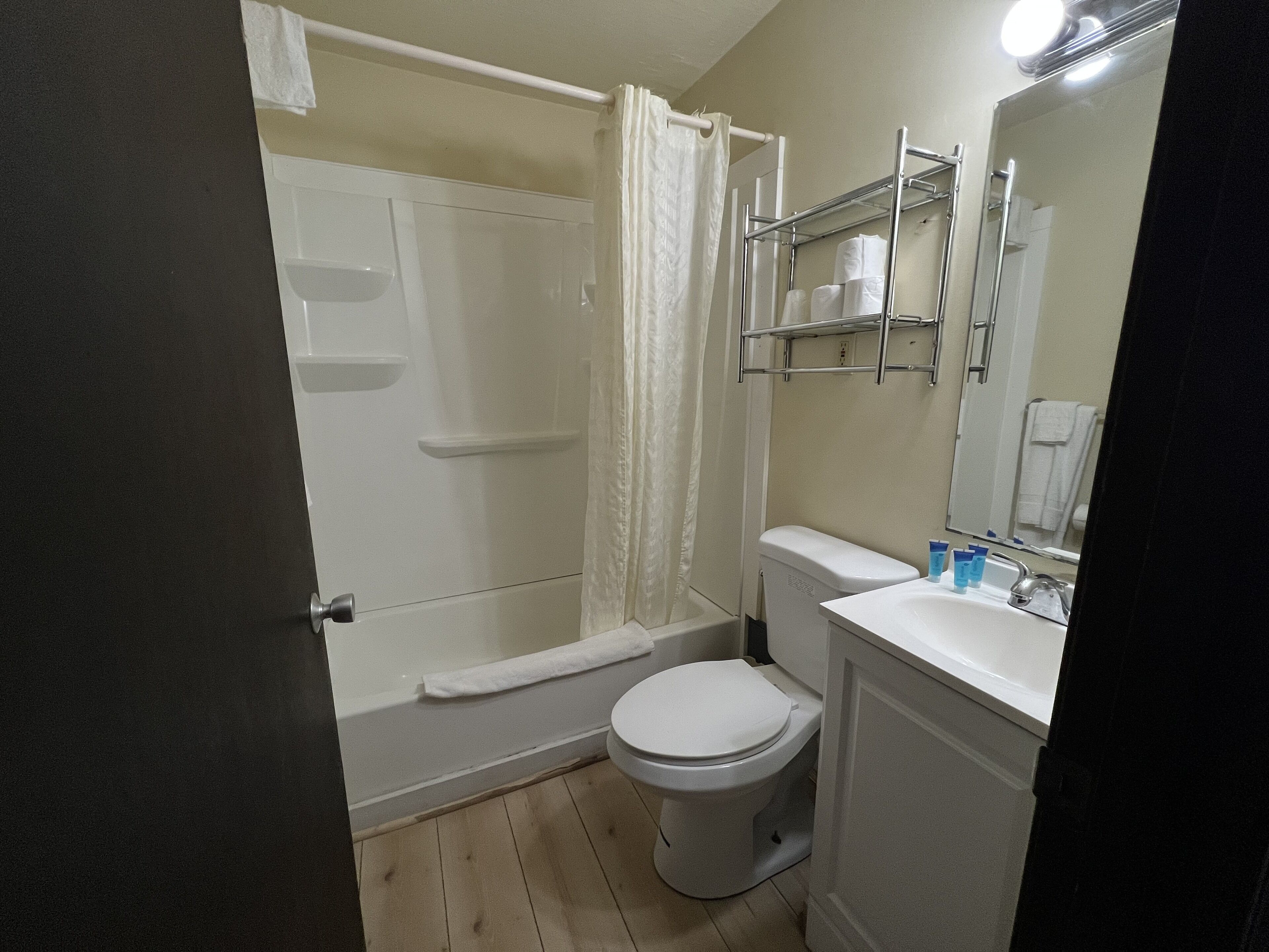 A bathroom with a shower, toilet, and sink.