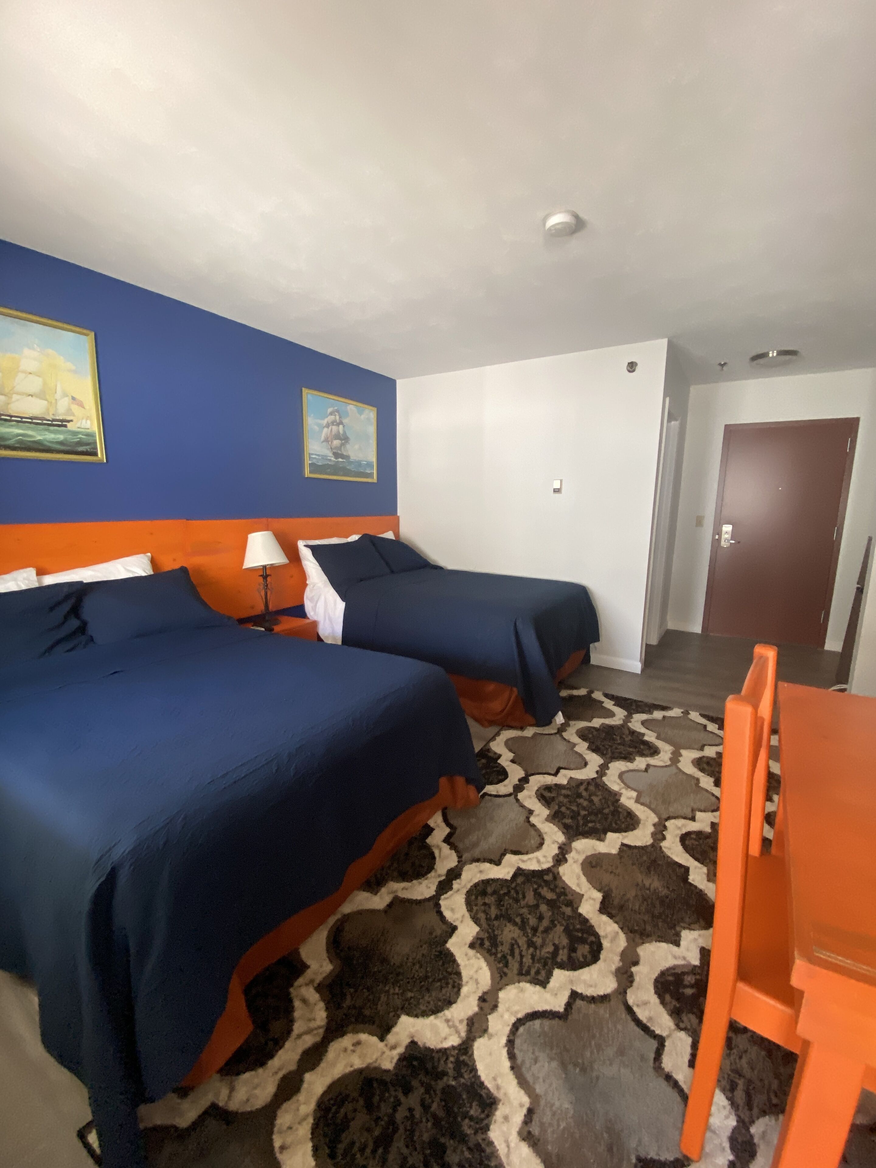 Ein Hotelzimmer mit zwei Betten, einem Tisch und Stühlen.