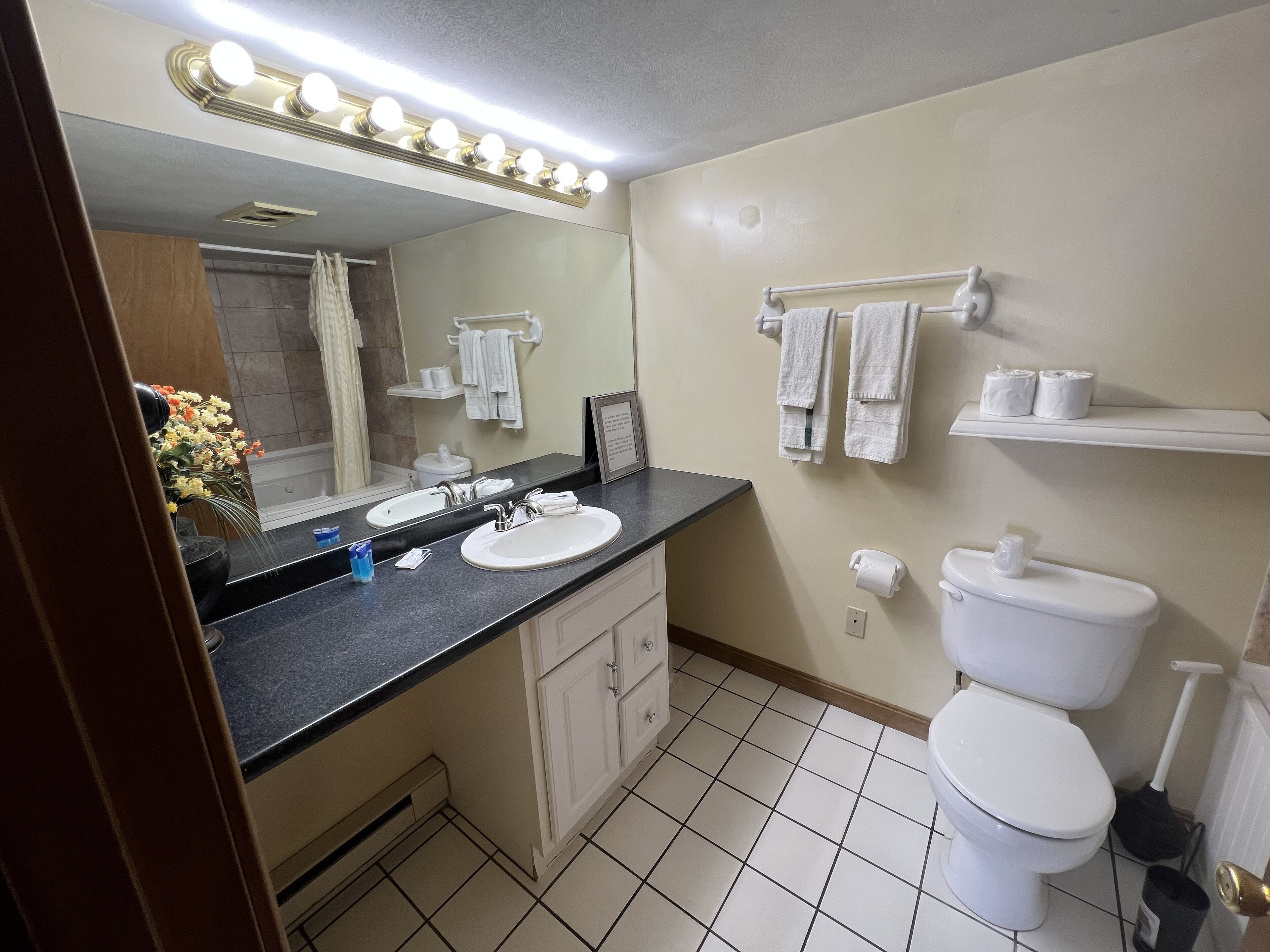 Une salle de bain avec deux lavabos, des toilettes, une douche et un meuble-lavabo avec des placards.