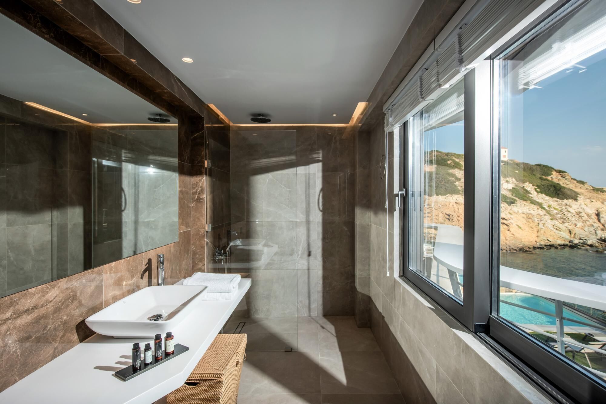 A modern bathroom with a large window, a bathtub, and a vanity with a sink.