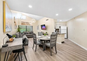 A modern living space with a dining area, kitchen, and seating area. - 3648 Orlando Vacational Apartment 2nd floor, Lake view (Orlando)