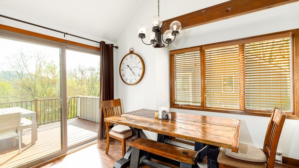 A dining area with a wooden table, chairs, and a chandelier.