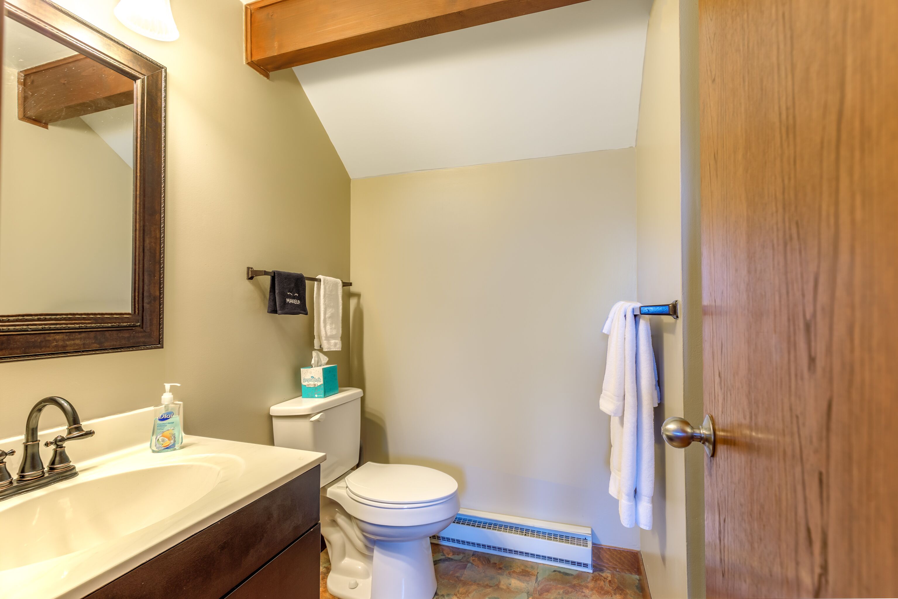 Une salle de bain avec un lavabo, des toilettes et un miroir.