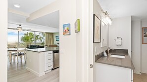 Uma cozinha moderna com máquina de lavar louça embutida, um espaço de refeições com vista e um banheiro com pia e porta-toalhas.