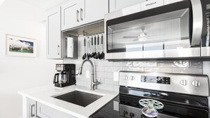 Een moderne keuken met een ingebouwde magnetron, oven en spoelbak.