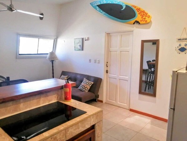 A compact living space with a kitchenette, a dining area, and a sofa.