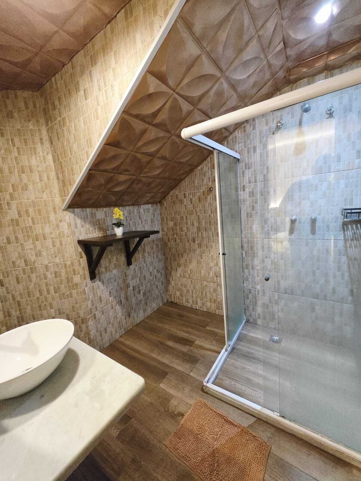 Ein Badezimmer mit Dusche, Waschbecken und Ablagefläche mit Pflanze.
