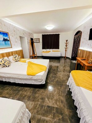 A hotel room with two beds, a wooden floor, a painting on the wall, and a window with curtains. -  Pousada Gente Bonita João Fernandes (Búzios)
