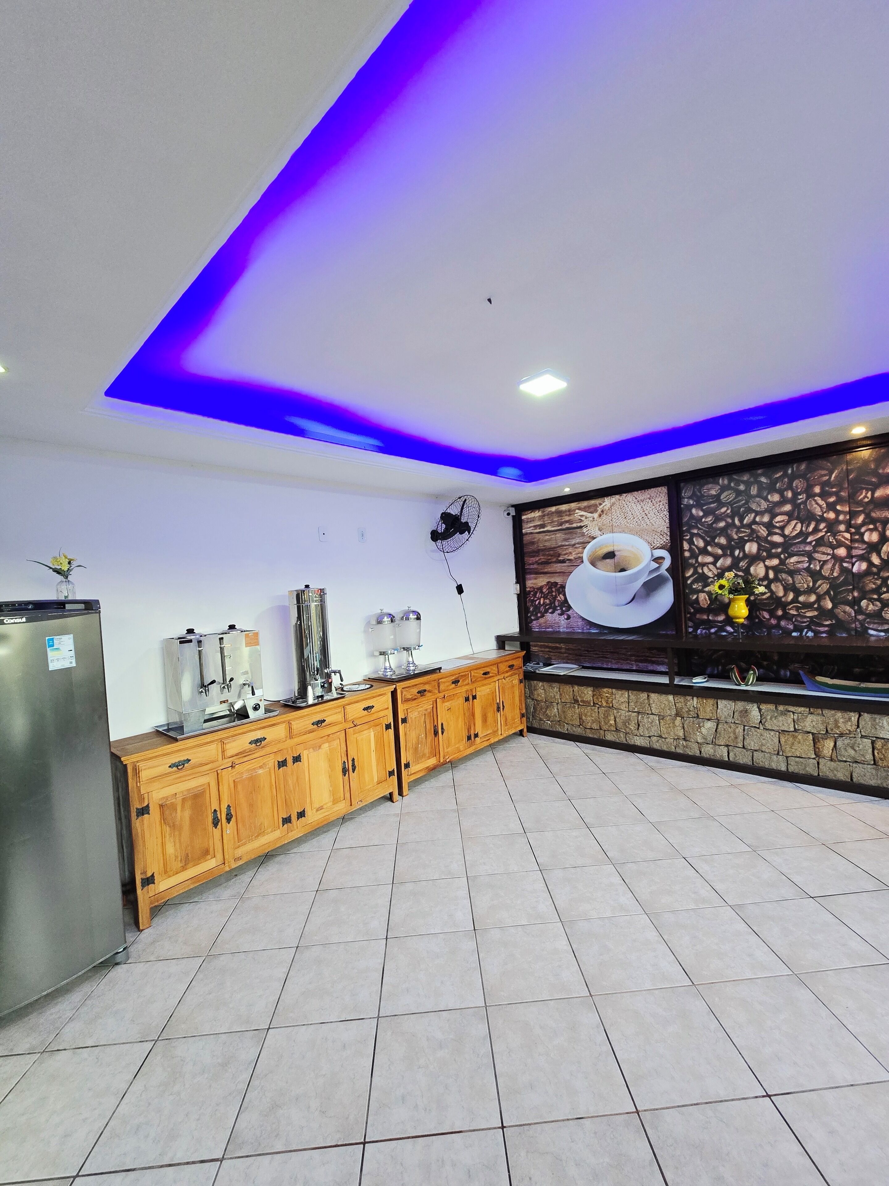 Una cocina moderna con cafetera integrada, armarios de madera y una pared decorativa de piedra.